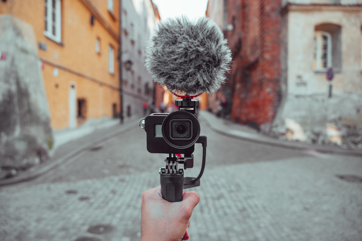 Hand holding a camera with microphone, content creation tools